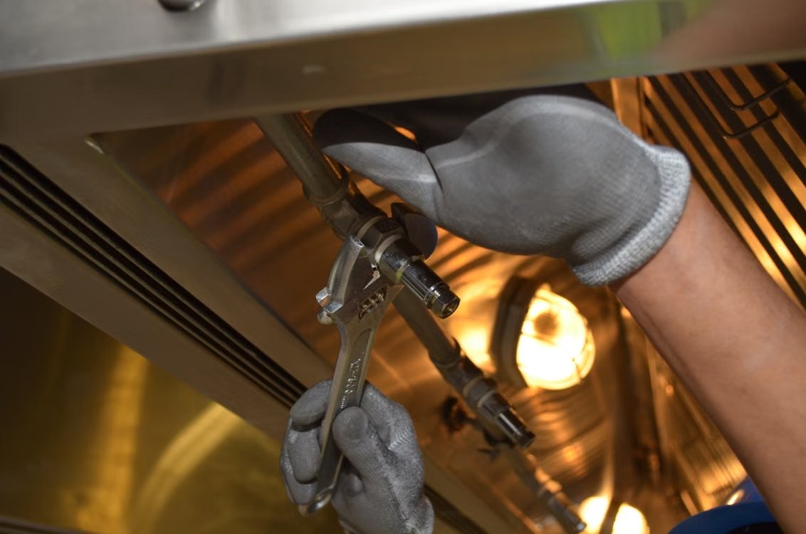 Plumber tightening a pipe fitting with a wrench